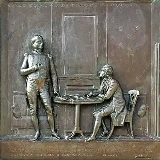  Bronze statue of Napoleon and another person with text engraved underneath reading "vous serez le Sully de Ste Hélène on ne pourra jamais s'arreter sur nos grands evenements, écrire sur ma personne sans avoir recours a vos mémoires. 21 Sept 1815" followed by what is presumably the artist's signature