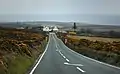 Looking down the steep descent towards the sharp right turn at Creg-ny-Baa, with the emergency slip-road to left of the pub and Kate's Cottage behind the camera position