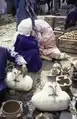 A market. A female potter and vendors of churn pots. Tomatoes, Tleta Beni Oulid, 1997