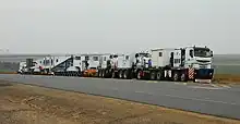 TII Nicolas Tractomas ballast tractors pulling hydraulic modular trailer with girder bridge.