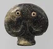Amulet in the form of a head of an elephant; 3500–3300&nbsp;BC; serpentine (the green part) and bone (the eyes); 3.5 × 3.6 × 2.1&nbsp;cm; Metropolitan Museum of Art (New York City)