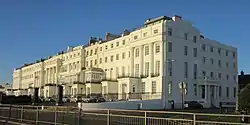 Block of white houses with a blue sky in the background