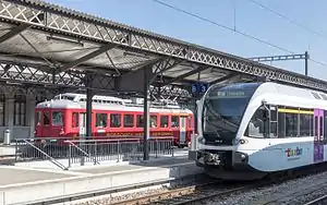 White train stopped at side platform
