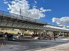 Concrete viaduct passing over street with station's construction site underneath