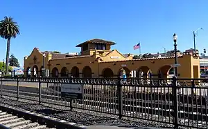 A yellow Mission-style railroad station building