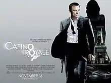 The poster shows Daniel Craig as James Bond, wearing a business suit with a loose tie and holding a gun. Behind him is a silhouette of a woman showing a building with a sign reading "Casino Royale" and a dark grey Aston Martin DBS below the building. At the bottom left of the image is the title "Casino Royale"&nbsp;– bothшп "O"s stand above each other, and below them is a 7 with a trigger and gun barrel, forming Bond's codename: "Agent 007"&nbsp;– and the credits.