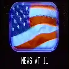 A windy American flag seen through a plane window; below reads "NEWS AT 11" in a font used by the US military.