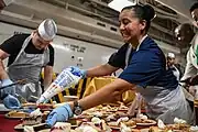 YNC Inez Cannon adds the topping to Thanksgiving dinner pie aboard USS&nbsp;Theodore Roosevelt (CVN-71).