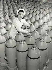 A worker tightens nose plugs of 500-pound bombs