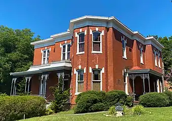 North Danville Italianate style Home. This two-story brick dwelling has an original veranda, two-story bay, arched windows with keystones, and rectangular wood panels at the cornice.
