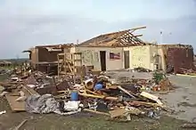 A heavily damaged home with much of its brick exterior and roof destroyed