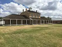 The post hospital, rebuilt in the 1980s, from the parade ground: The north ward is the leftmost section of the building.