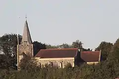 A church with tower and spire surrounded by trees