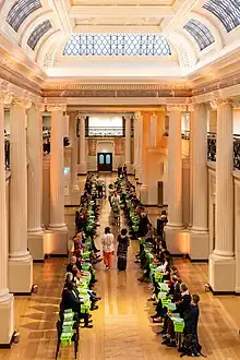 People seated in a bright heritage space with columns and bookshelves