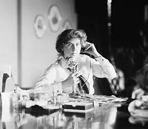 An American candlestick telephone being used by Genevieve Clark Thomson, circa 1915.