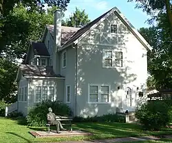 Two-story half-timbered house; statue of Norris seated on park bench in front