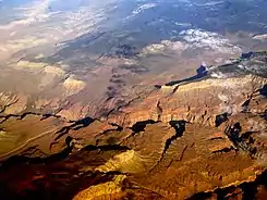 Aerial view – WNW of The Esplanade (Grand Canyon), south bank of Colorado River, with Toroweap Fault–(Prospect Canyon) as west borderUinkaret volcanic field at NW; Lava Falls below in Colorado River