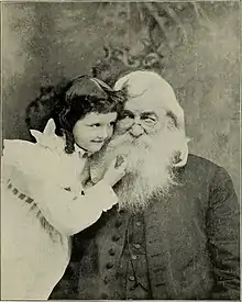 Little white girl with old bearded white man, in an affectionate embrace.