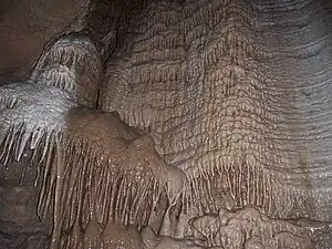 Image 11A flowstone formation inside Chimney Dome, part of Illinois Caverns in Monroe County. The cave is formed in limestone and dolomite by water dissolution and features stalactites, stalagmites, rimstone dams, flowstone, and soda straws.Photo credit: A. Frierdich (from Portal:Illinois/Selected picture)