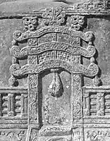 Jain torana with triratna symbols and flame palmette designs on top.