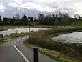 The dead hedge alongside this cycleway is protecting a wildlife pond among the 'Kingfisher Pools' at St Nicholas' Park, Warwick, England.