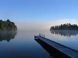 Image 3Lake MapourikaPhoto credit: Richard PalmerMorning mist on Lake Mapourika, a lake on the West Coast of New Zealand's South Island. It is the largest of the west coast lakes, a glacier formation from the last ice age. It is filled with fresh rain water which runs through the surrounding forest floor, collecting tannins and giving it its dark colour.