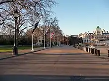 View along Horse Guards Parade with trees on the left and a building on the right.