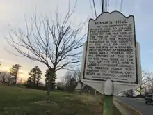 A historic marker located on top of the mostly flat summit of Minor's Hill.