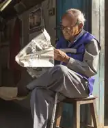 Photo of a man reading a newspaper