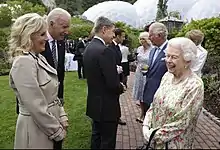 in an outdoor setting, the Queen and Biden are laughing