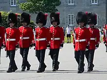 The Royal 22nd Regiment's full dress headgear is a bearskin cap with a scarlet plume.