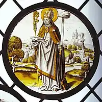 Renaissance roundel using only black or brown glass paint, and silver stain. The bishop-saint Lambrecht of Maastricht stands in an extensive landscape, 1510–20. Diameter 8+3⁄4&nbsp;in (22&nbsp;cm). Designed to be placed low, close to the viewer.