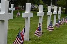 White grave markers with flags