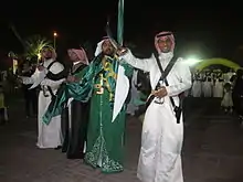 Image 3Saudi males dressed and prepared for ardah, the national dance. It also includes swords, poetry, and singing. (from Culture of Saudi Arabia)