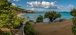 View of Sea Grapes Beach at the Rex Resorts’ Hawksbill Hotel at Five Islands with world’s largest yacht at anchor off Hawksbill Bay.