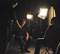 Tim Roth (center), star of Lie to Me, is wired for sound by PA Travis Rexroat while co-director Paul Mariano looks on.