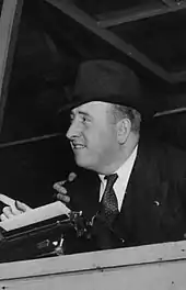 A black and white photograph of Red Burnett reporting at a sports event in 1930