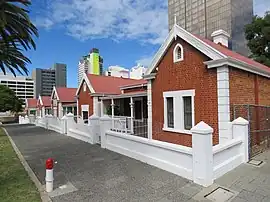Red brick cottages with white fences in front