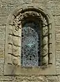 Stone window surround decorated with fossils, plants and pinecones at St Mary's, Wreay